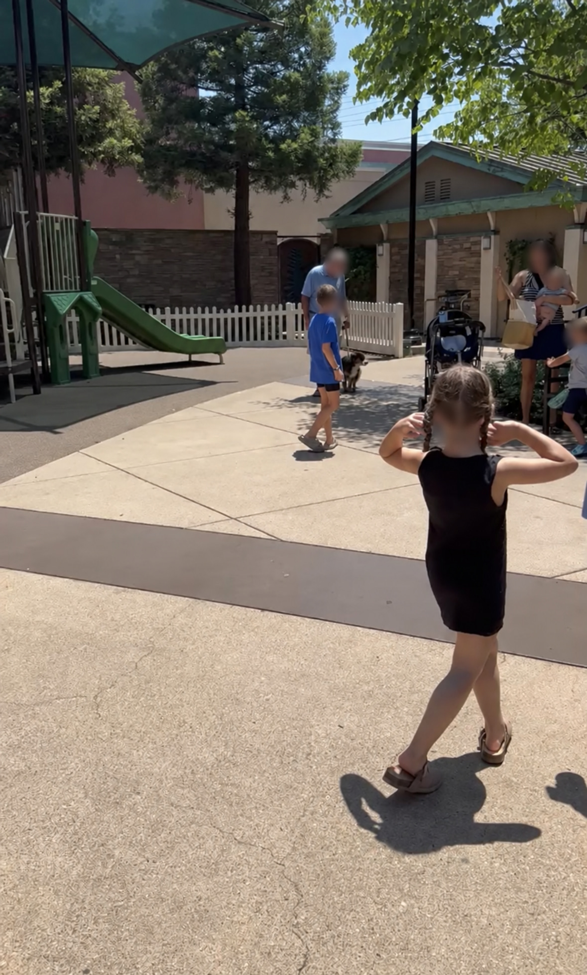 Bear calmly visiting a city park around children and adults, whose faces are blurred for privacy